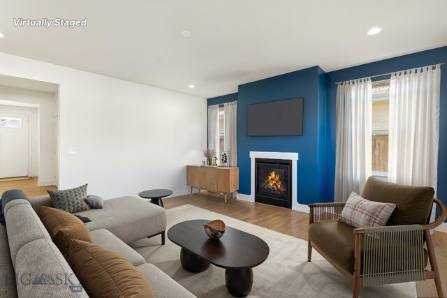 1606 Wyatt Earp Ct, Belgrade, MT 59714 - living area with plenty of natural light, a glass covered fireplace, light wood-style flooring, and recessed lighting