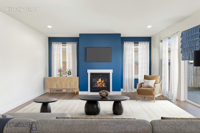 1606 Wyatt Earp Ct, Belgrade, MT 59714 - living room with a glass covered fireplace, wood finished floors, and recessed lighting