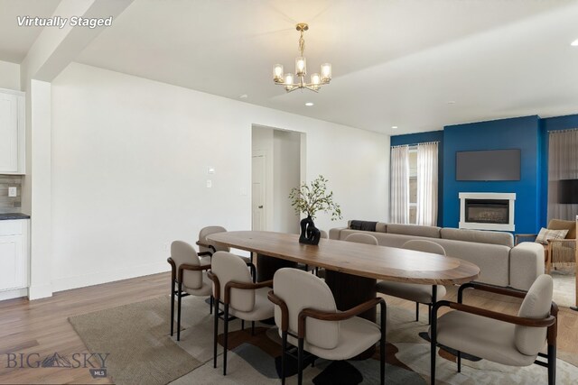 1606 Wyatt Earp Ct, Belgrade, MT 59714 - dining space featuring wood finished floors, a large fireplace, a chandelier, and recessed lighting