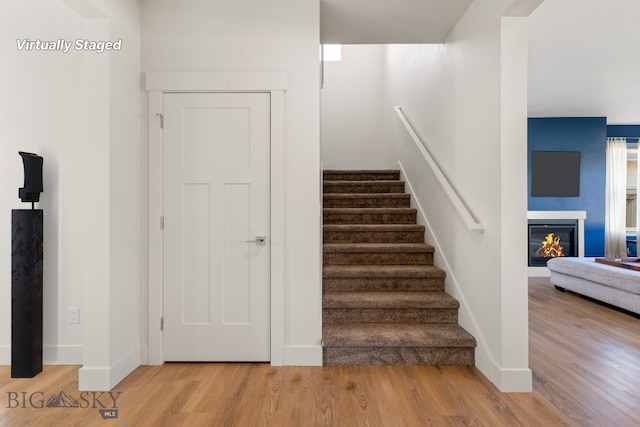 1606 Wyatt Earp Ct, Belgrade, MT 59714 - stairs featuring wood finished floors and a glass covered fireplace