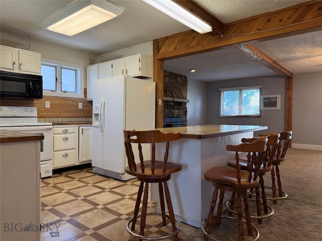 512 W 4th Ave, Big Timber, MT 59011 - kitchen with white appliances, a breakfast bar area, white cabinets, and beamed ceiling
