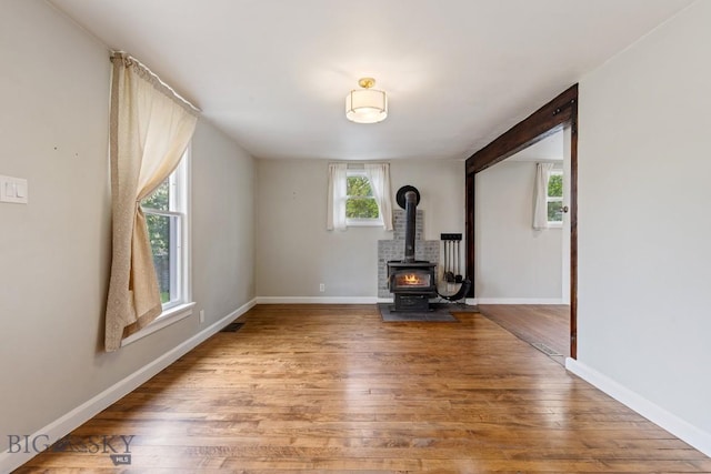 209 N 3rd Ave, Bozeman, MT 59715 - unfurnished living room with wood finished floors and a wood stove