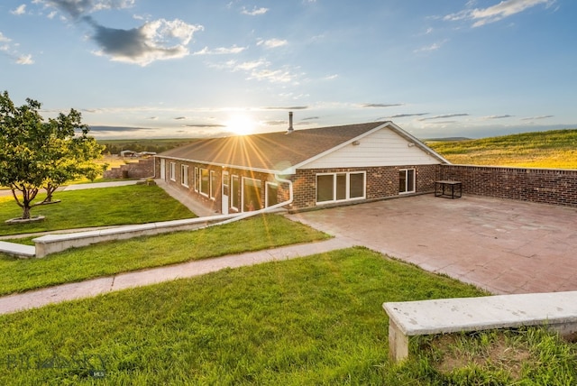 181 Pheasant Ln, Belgrade, MT 59714 - back of house with brick siding, a yard, a patio, and a garage