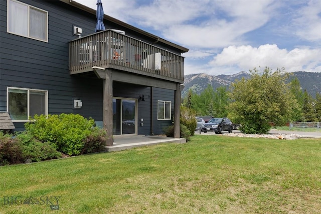120 Firelight Dr Unit C10, Big Sky, MT 59716 - rear view of house with a mountain view, a balcony, a lawn, and a patio