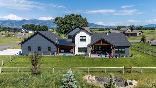 16 Tight Loop Dr, Bozeman, MT 59718 - back of house with board and batten siding, a patio area, a mountain view, and a fenced backyard