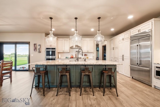 16 Tight Loop Dr, Bozeman, MT 59718 - kitchen featuring stainless steel appliances, light wood-style flooring, white cabinetry, recessed lighting, and a large island