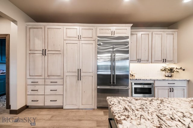 16 Tight Loop Dr, Bozeman, MT 59718 - kitchen featuring appliances with stainless steel finishes, light stone counters, light wood-type flooring, white cabinets, and recessed lighting