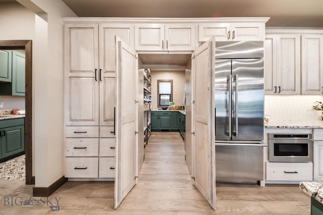 16 Tight Loop Dr, Bozeman, MT 59718 - kitchen featuring appliances with stainless steel finishes, light wood-style flooring, light stone counters, and green cabinetry