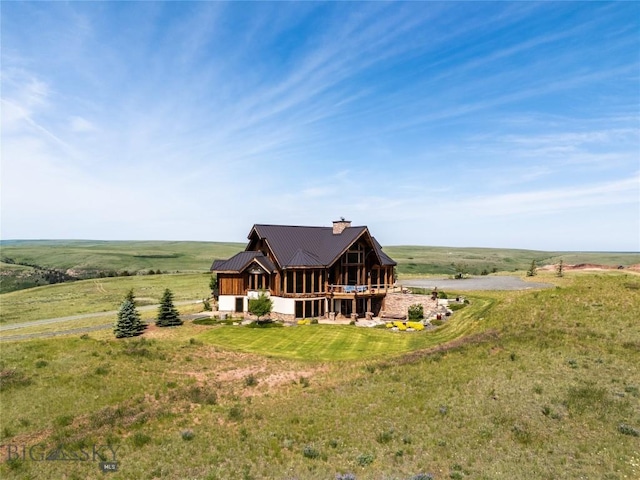 155 Peacemaker Ridge Rd, Belt, MT 59412 - back of property featuring a chimney, a metal roof, a lawn, and a view of countryside