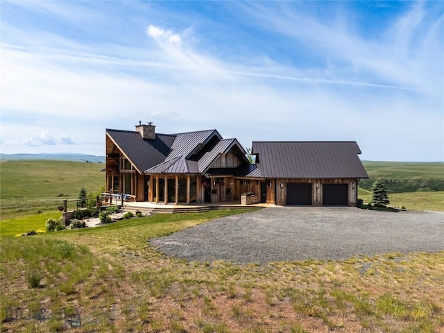 155 Peacemaker Ridge Rd, Belt, MT 59412 - view of front of home with driveway, an attached garage, a metal roof, and a chimney