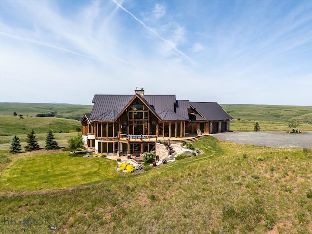155 Peacemaker Ridge Rd, Belt, MT 59412 - rear view of property featuring an attached garage, driveway, a chimney, a metal roof, and a view of rural / pastoral area