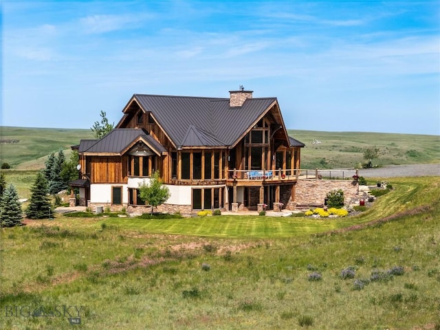 155 Peacemaker Ridge Rd, Belt, MT 59412 - rear view of house with a chimney, stone siding, a metal roof, and a lawn