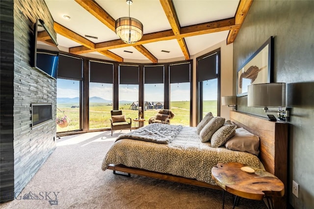 155 Peacemaker Ridge Rd, Belt, MT 59412 - carpeted bedroom featuring multiple windows, coffered ceiling, beam ceiling, a stone fireplace, and access to outside