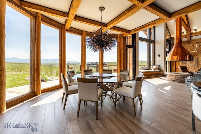 155 Peacemaker Ridge Rd, Belt, MT 59412 - dining space with a chandelier, coffered ceiling, a mountain view, beamed ceiling, and wood finished floors
