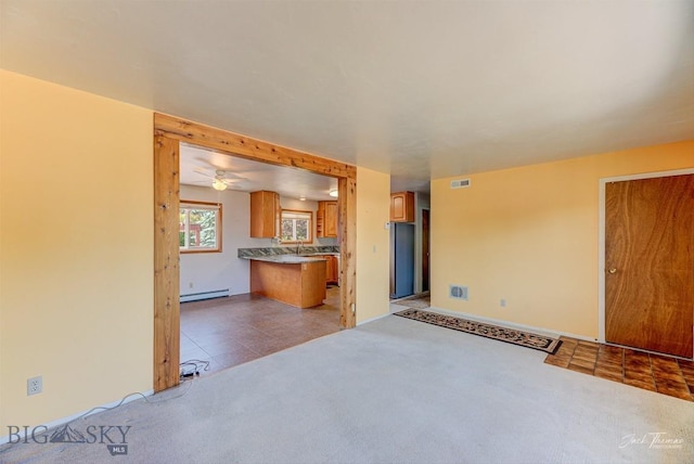 425 Russell, Helena, MT 59602 - unfurnished living room featuring baseboard heating, light carpet, and a ceiling fan