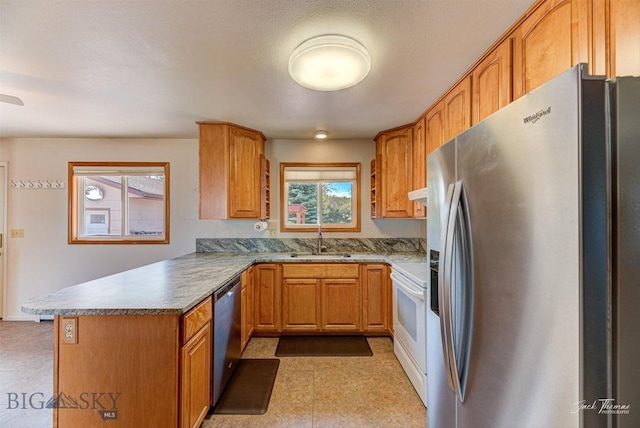 425 Russell, Helena, MT 59602 - kitchen featuring stainless steel appliances, a peninsula, and brown cabinetry