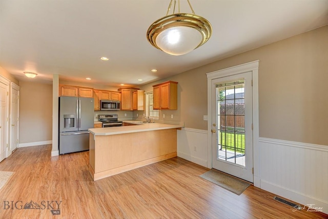 9 Sand Piper, Helena, MT 59602 - kitchen with appliances with stainless steel finishes, a peninsula, wainscoting, light countertops, and light wood finished floors