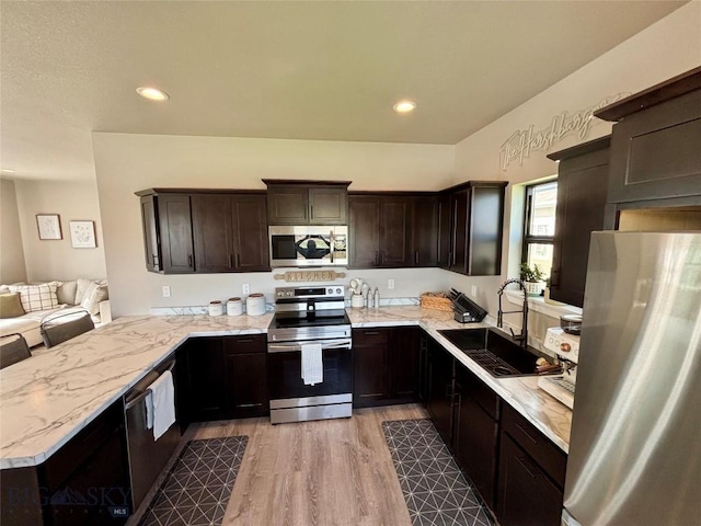 165 Johnson Ave, Dillon, MT 59725 - kitchen with appliances with stainless steel finishes, dark brown cabinets, light wood-type flooring, a peninsula, and recessed lighting