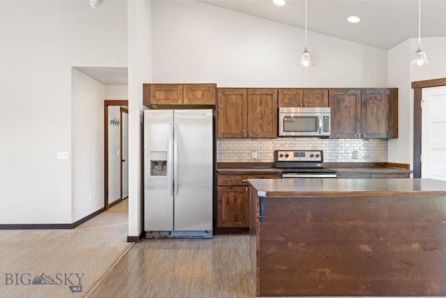 343 Stewart Loop, Bozeman, MT 59718 - kitchen featuring appliances with stainless steel finishes, tasteful backsplash, high vaulted ceiling, dark countertops, and pendant lighting