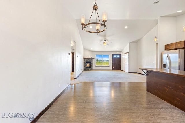 343 Stewart Loop, Bozeman, MT 59718 - unfurnished living room with a chandelier, light wood-style floors, a fireplace, ceiling fan, and recessed lighting