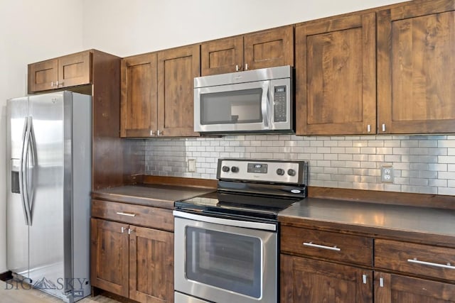 343 Stewart Loop, Bozeman, MT 59718 - kitchen featuring appliances with stainless steel finishes, dark countertops, and tasteful backsplash