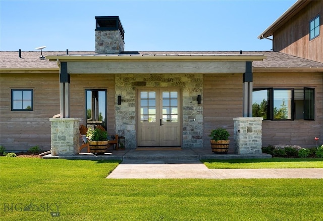75 Vera Ct, Bozeman, MT 59718 - property entrance with a yard, a chimney, stone siding, and french doors