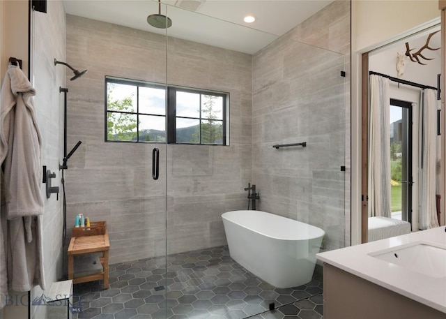 75 Vera Ct, Bozeman, MT 59718 - bathroom with tile walls, a stall shower, a soaking tub, vanity, and tile patterned flooring