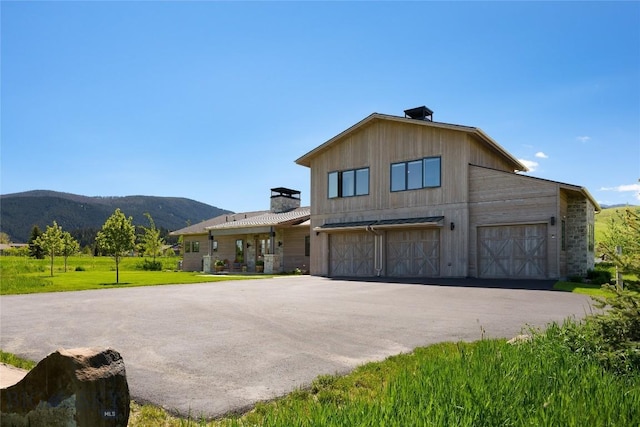 75 Vera Ct, Bozeman, MT 59718 - view of front of home featuring a chimney, a mountain view, a garage, and a front lawn
