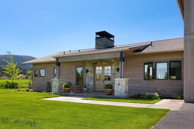 75 Vera Ct, Bozeman, MT 59718 - view of front facade featuring a front yard, a chimney, a mountain view, and a shingled roof