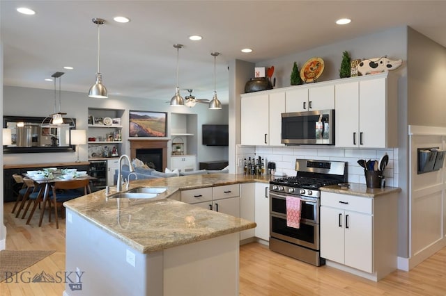 3214 Hillcrest Dr, Bozeman, MT 59715 - kitchen with appliances with stainless steel finishes, open floor plan, light wood-style floors, recessed lighting, and light stone counters