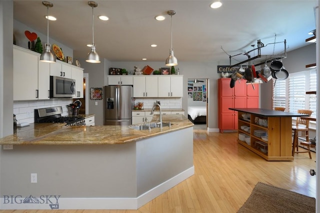 3214 Hillcrest Dr, Bozeman, MT 59715 - kitchen with stainless steel appliances, decorative backsplash, a peninsula, recessed lighting, and hanging light fixtures