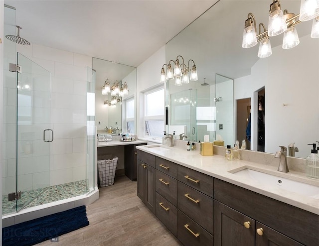 3214 Hillcrest Dr, Bozeman, MT 59715 - full bathroom featuring a chandelier, a shower stall, wood finished floors, and double vanity