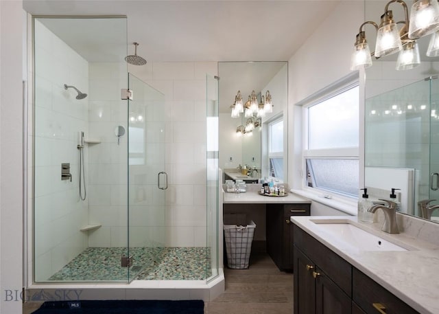 3214 Hillcrest Dr, Bozeman, MT 59715 - bathroom with a shower stall, vanity, wood finished floors, and a chandelier