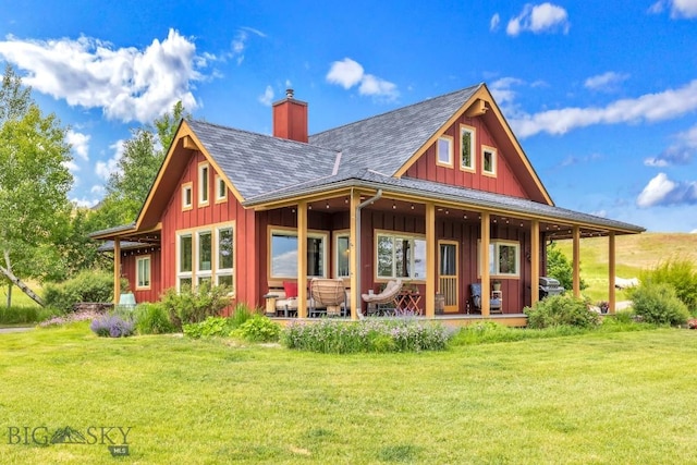 13 Blue Wing Rd, Ennis, MT 59729 - back of property featuring board and batten siding, a chimney, a lawn, and a shingled roof