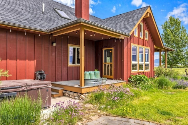 13 Blue Wing Rd, Ennis, MT 59729 - back of house featuring a hot tub, a shingled roof, board and batten siding, and a chimney