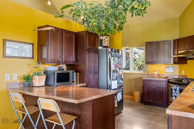 13 Blue Wing Rd, Ennis, MT 59729 - kitchen featuring stainless steel appliances, under cabinet range hood, a peninsula, light countertops, and a breakfast bar