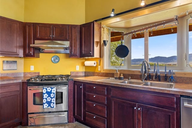 13 Blue Wing Rd, Ennis, MT 59729 - kitchen with appliances with stainless steel finishes, dark brown cabinets, under cabinet range hood, and a mountain view