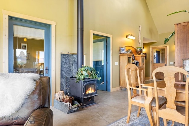 13 Blue Wing Rd, Ennis, MT 59729 - dining area featuring a wood stove, concrete flooring, and high vaulted ceiling