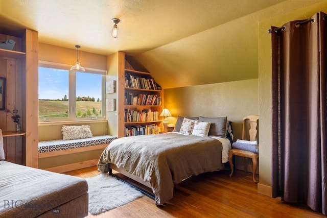13 Blue Wing Rd, Ennis, MT 59729 - bedroom with wood finished floors, vaulted ceiling, and a textured wall