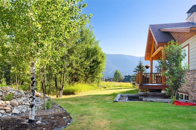 3140 Two Moons Rd, Big Sky, MT 59716 - view of green lawn with a deck with mountain view