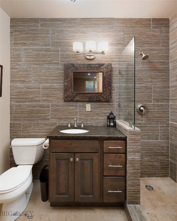 3140 Two Moons Rd, Big Sky, MT 59716 - bathroom featuring tile walls, vanity, tiled shower, and tile patterned flooring