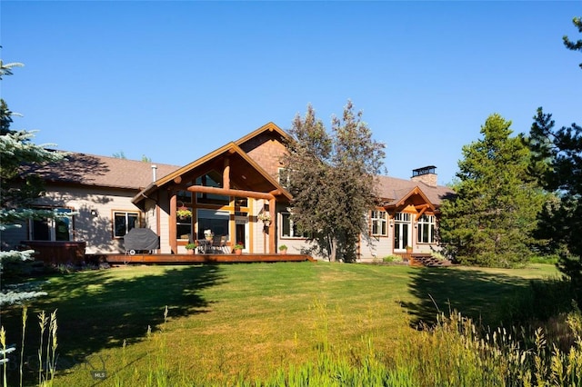 3140 Two Moons Rd, Big Sky, MT 59716 - back of property with a yard, a chimney, and a wooden deck
