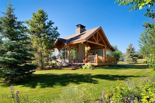 3140 Two Moons Rd, Big Sky, MT 59716 - view of front facade featuring a chimney, a front yard, and a wooden deck