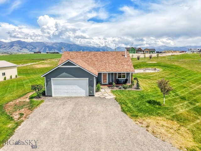 418 May Ln, Belgrade, MT 59714 - view of front of property with a mountain view, driveway, a porch, a front yard, and a garage