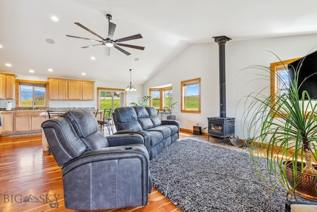 418 May Ln, Belgrade, MT 59714 - living room with a ceiling fan, plenty of natural light, vaulted ceiling, a wood stove, and light wood-style flooring