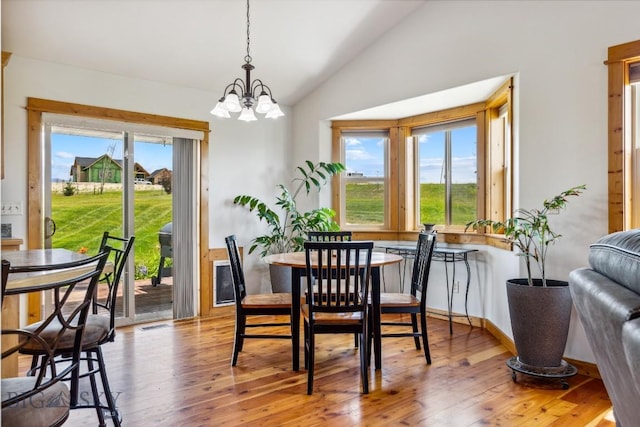 418 May Ln, Belgrade, MT 59714 - dining area featuring vaulted ceiling, plenty of natural light, hardwood / wood-style flooring, and a chandelier