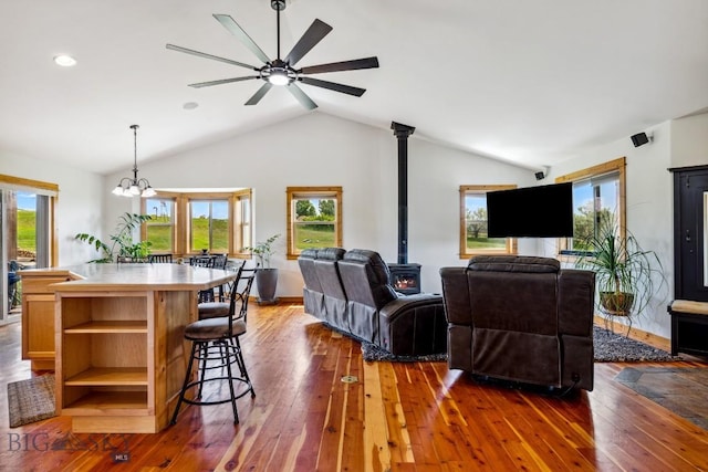 418 May Ln, Belgrade, MT 59714 - living area featuring vaulted ceiling, dark wood-type flooring, a chandelier, a wood stove, and ceiling fan