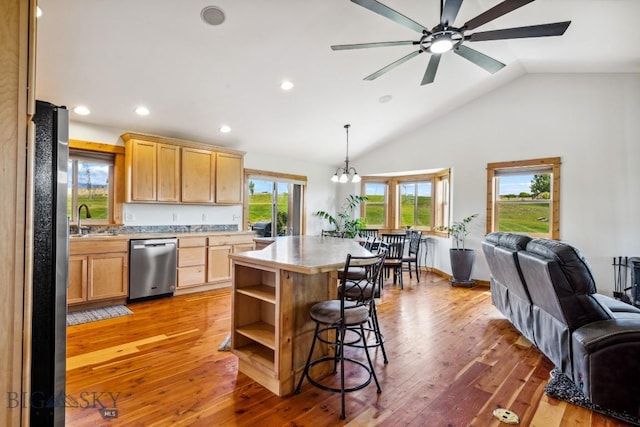 418 May Ln, Belgrade, MT 59714 - kitchen featuring appliances with stainless steel finishes, open floor plan, light brown cabinetry, a ceiling fan, and a breakfast bar