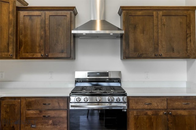702 Pleiades, Livingston, MT 59047 - kitchen with stainless steel range with gas stovetop, wall chimney exhaust hood, dark brown cabinetry, and light countertops