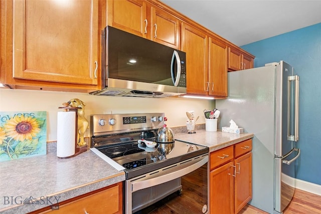 944 Forest Glen Dr, Bozeman, MT 59718 - kitchen featuring appliances with stainless steel finishes, brown cabinets, light countertops, and light wood-type flooring